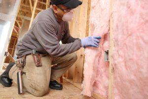 fiberglass batt insulation being installed